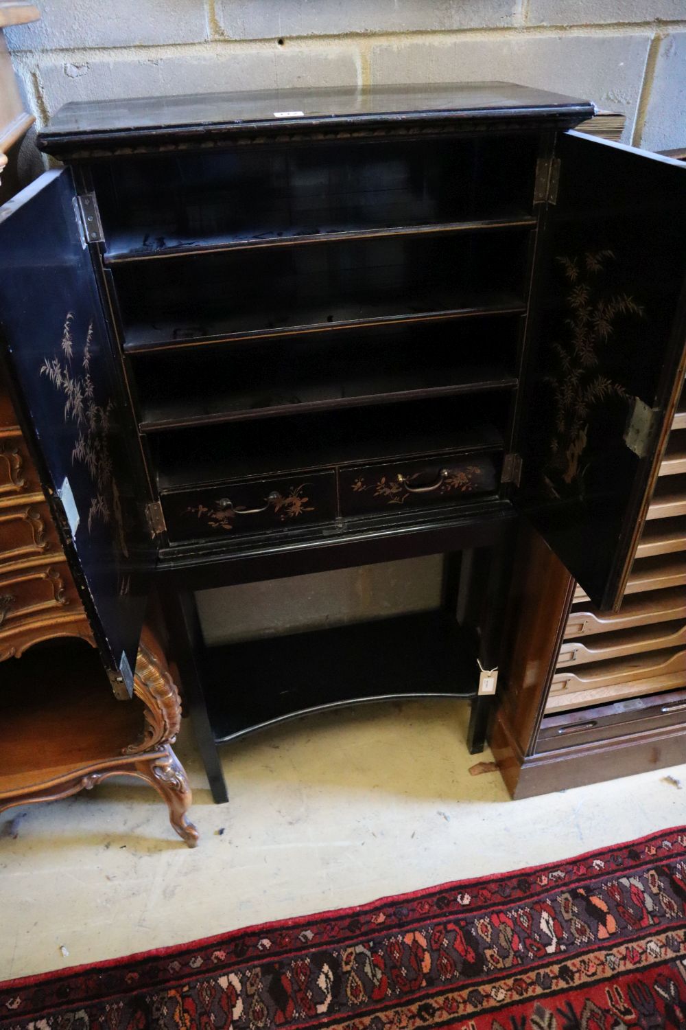 A 19th century chinoiserie cabinet on later ebonised stand, width 63cm, depth 27cm, height 130cm